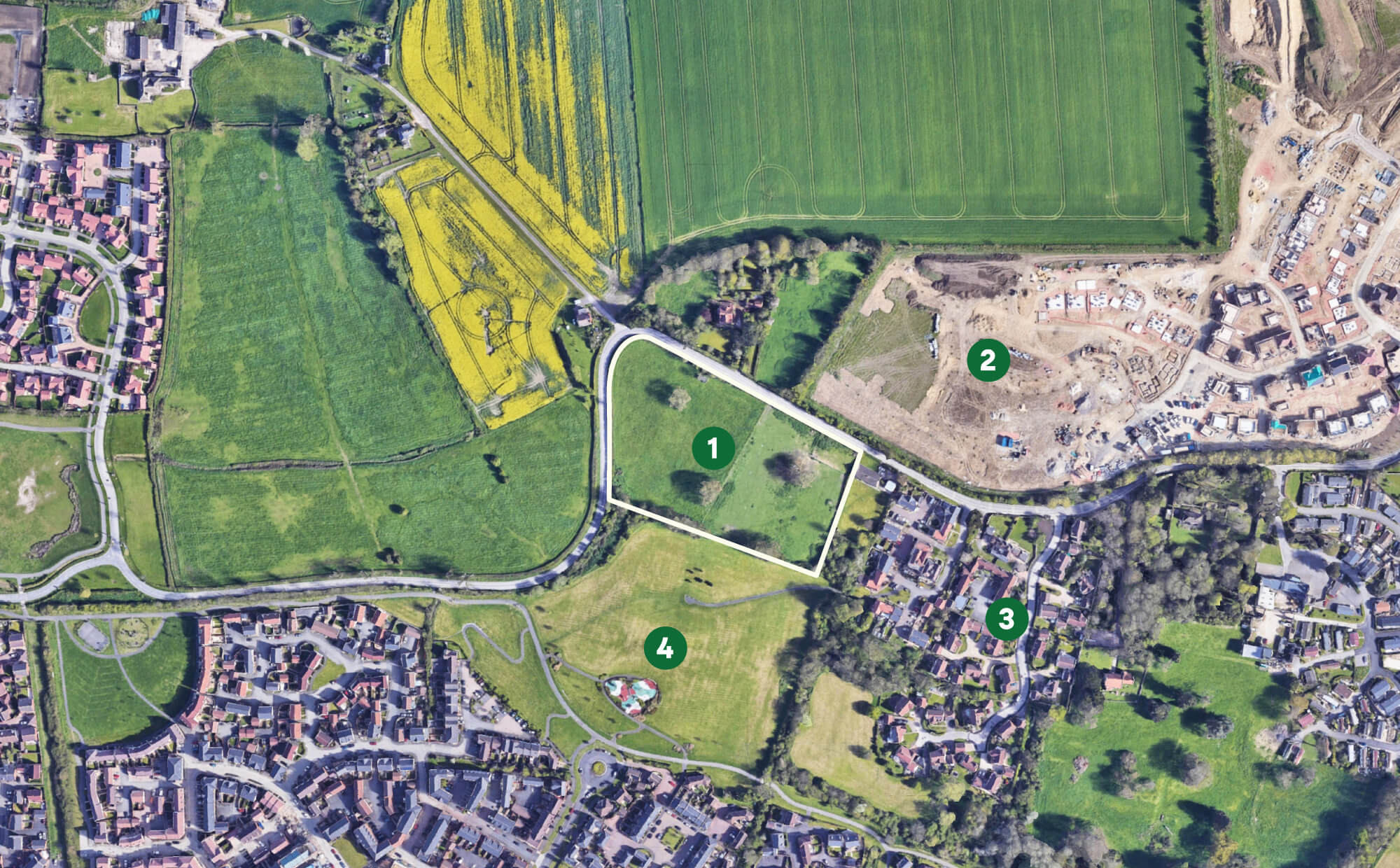 Aerial view of a mixed rural and residential area showing numbered zones: green fields, construction site, housing clusters, and a park with playground.